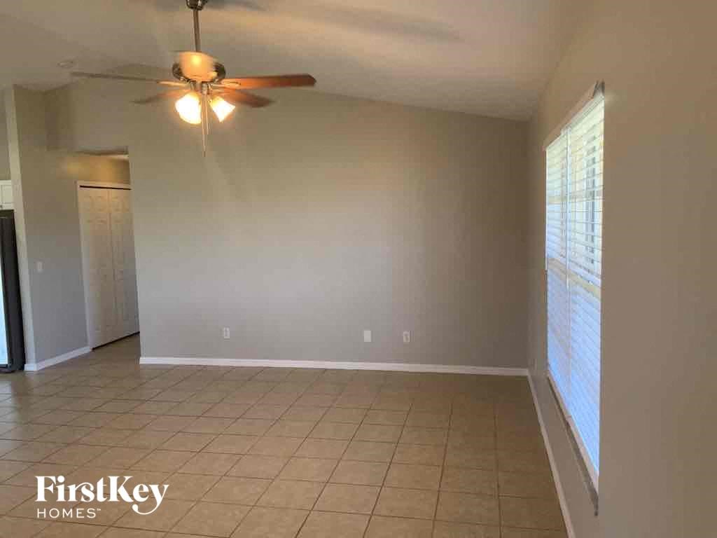 A room with a ceiling fan and tiled floor.