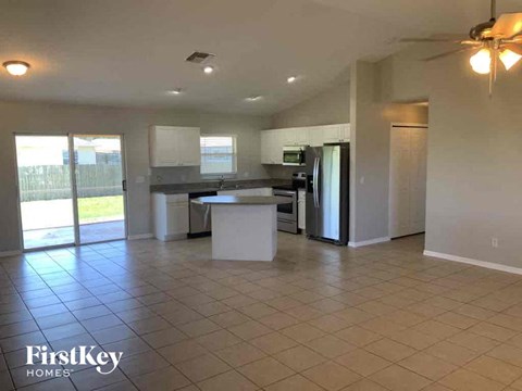 A kitchen with a refrigerator, sink, and oven.