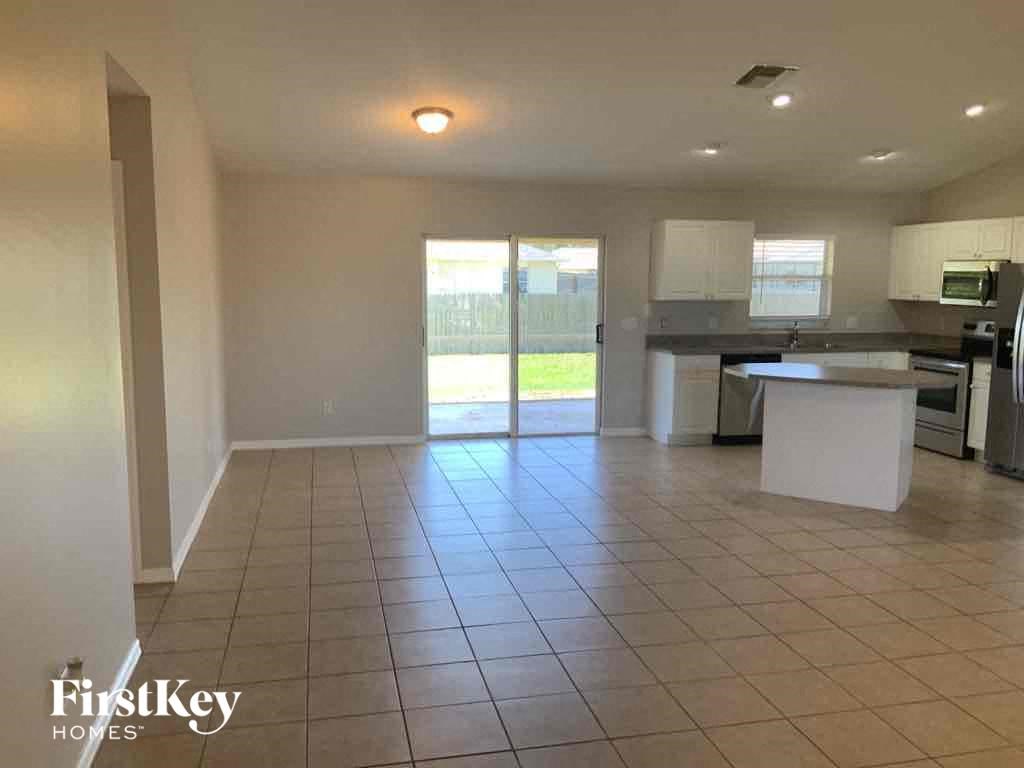 A kitchen area with a white countertop and a tiled floor.