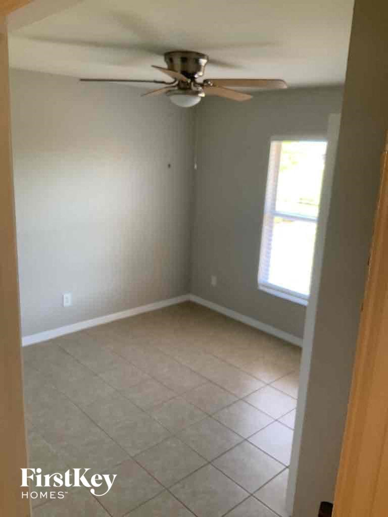 A room with a ceiling fan and a window.