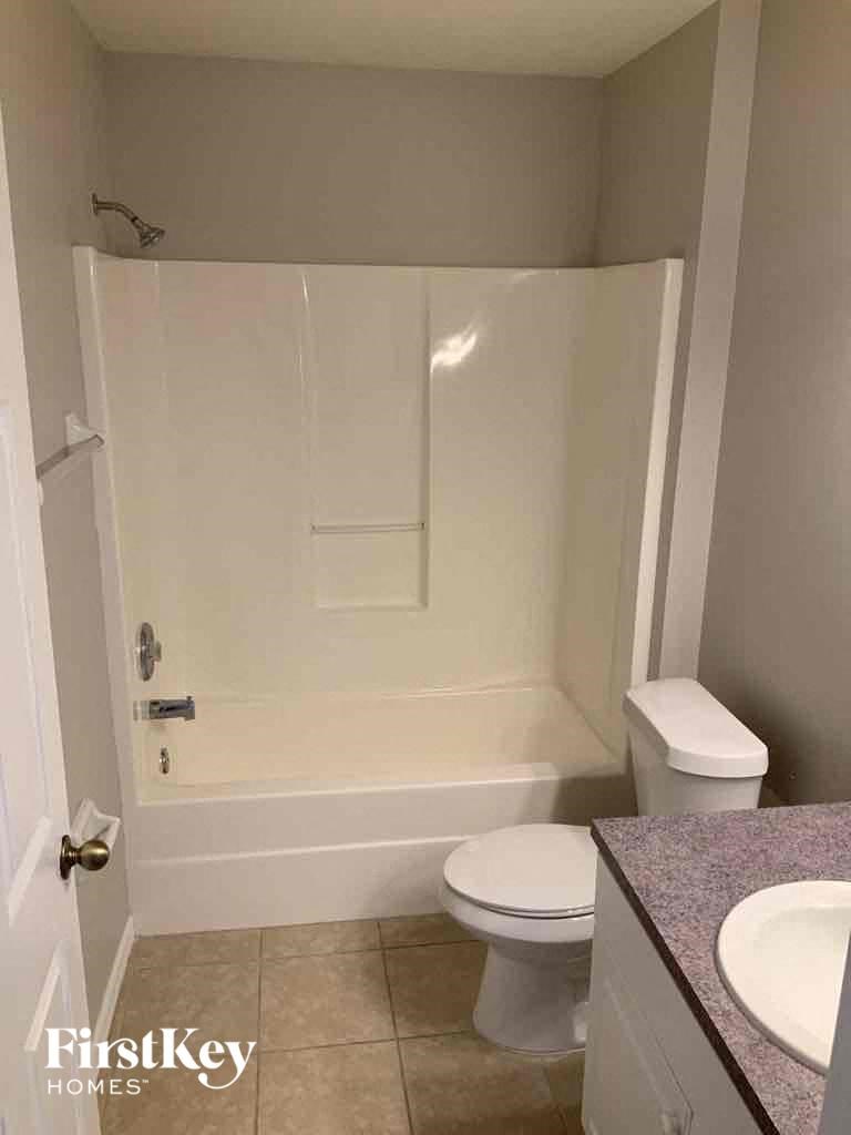 A white toilet sits next to a sink in a small bathroom.