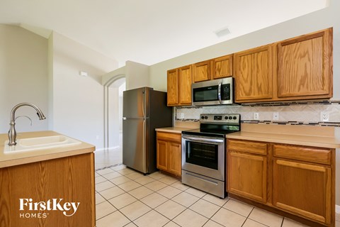 A kitchen with wooden cabinets and a stainless steel refrigerator.