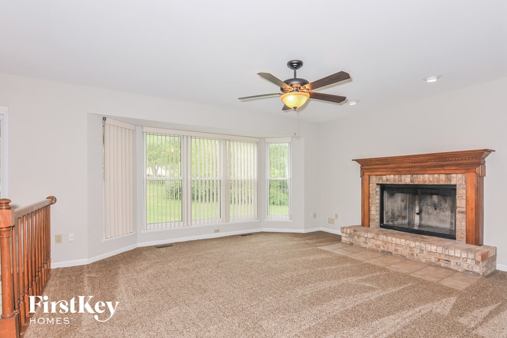 a living room with a fireplace and a ceiling fan