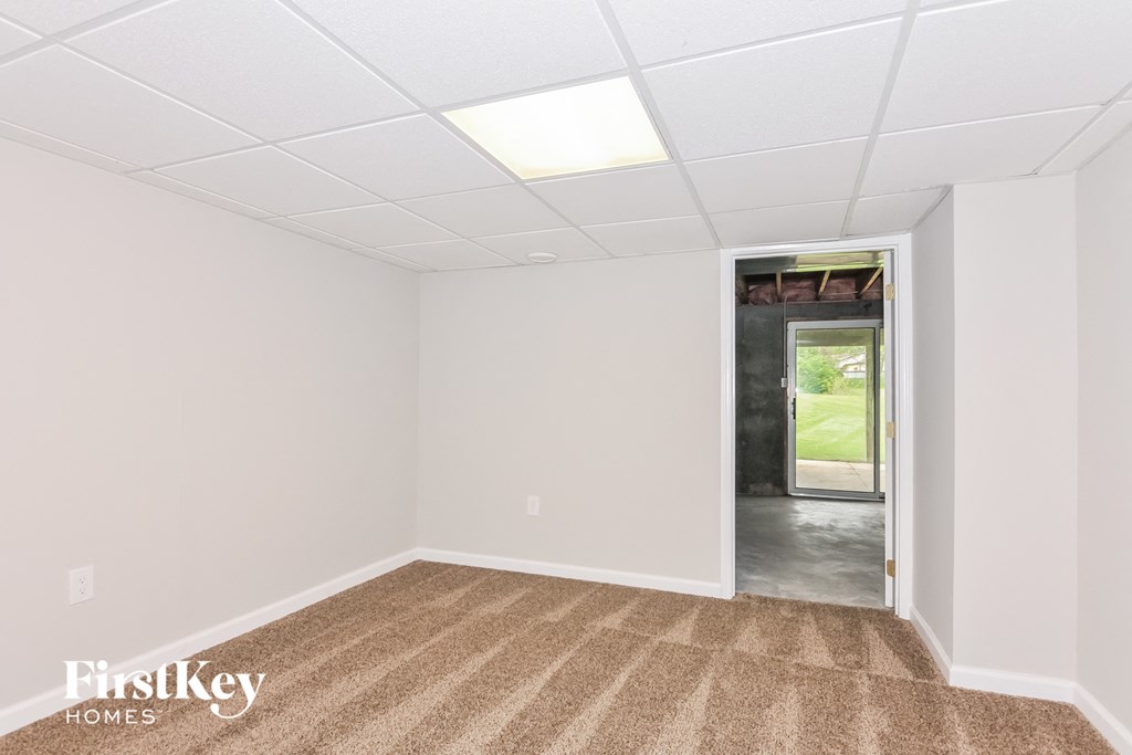 a white room with a carpet and a door to a hallway