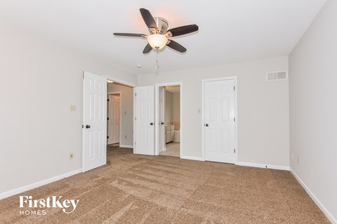 a living room with carpet and a ceiling fan