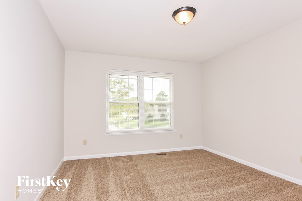 a spacious living room with carpet and a window