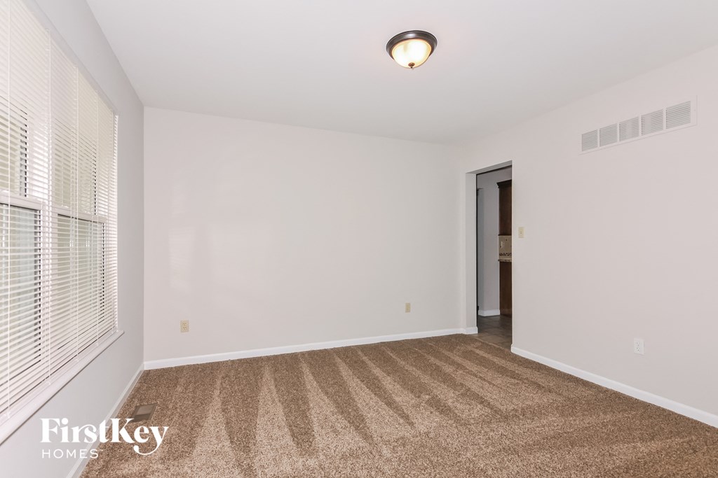 a spacious living room with carpet and a large window