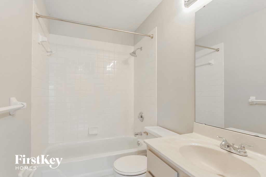 a white bathroom with a tub and a sink and a toilet