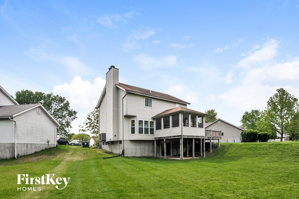 a white house with a porch on a green lawn