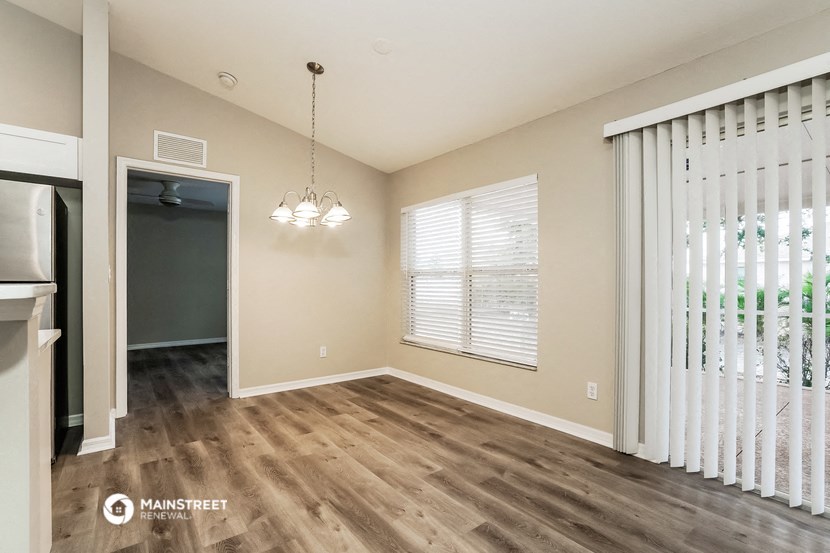 the living room and dining room of a house with wood flooring
