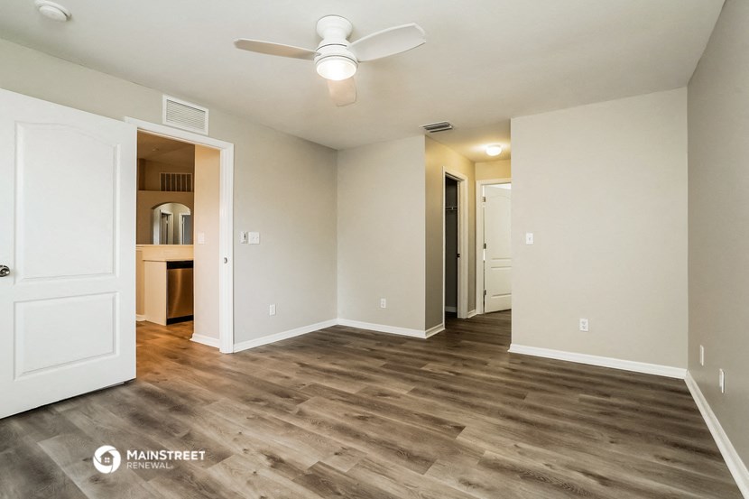 a renovated living room with white walls and a ceiling fan