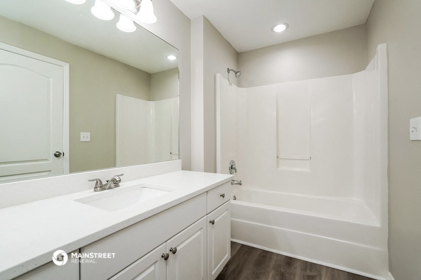 a bathroom with a sink and a tub and a mirror
