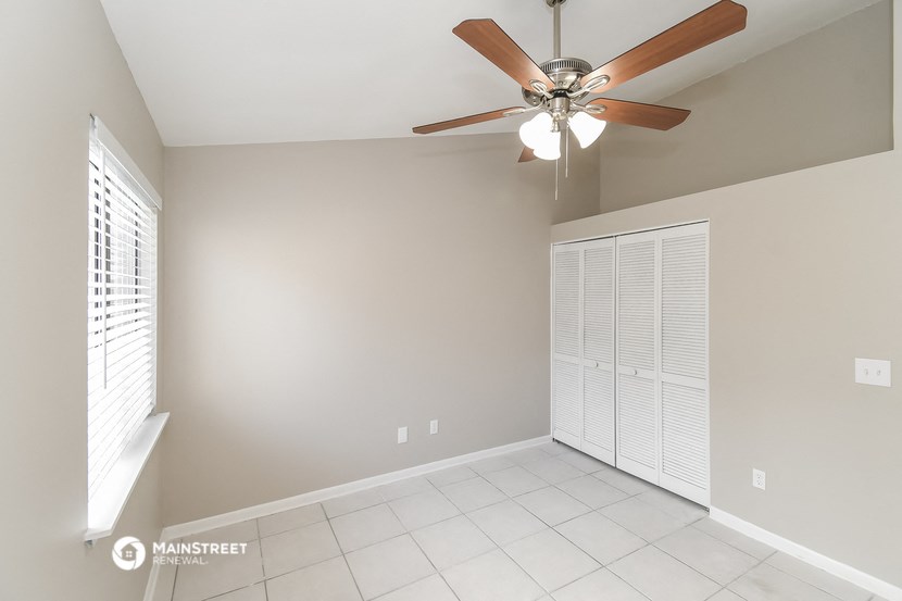 the living room has a ceiling fan and a tiled floor