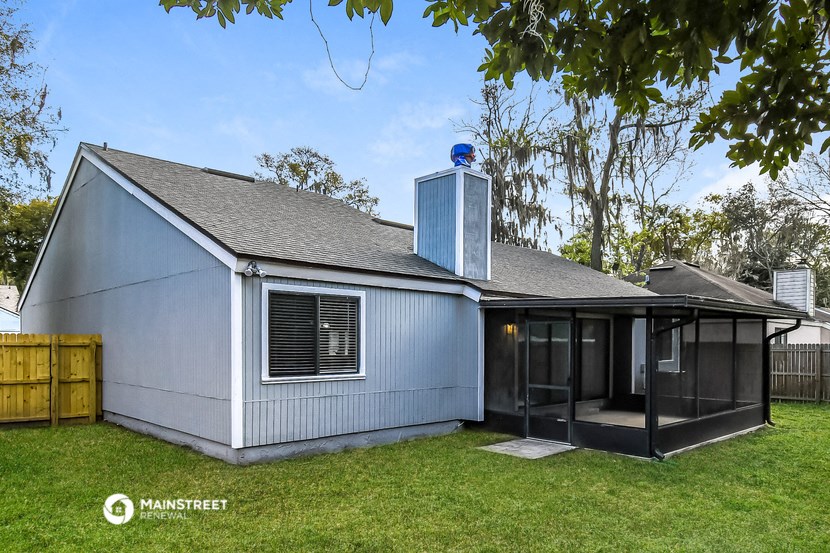 a white house with a grey roof and a chimney on top of it