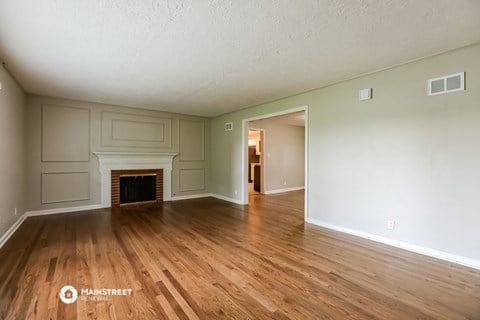 the living room with fireplace and wood flooring