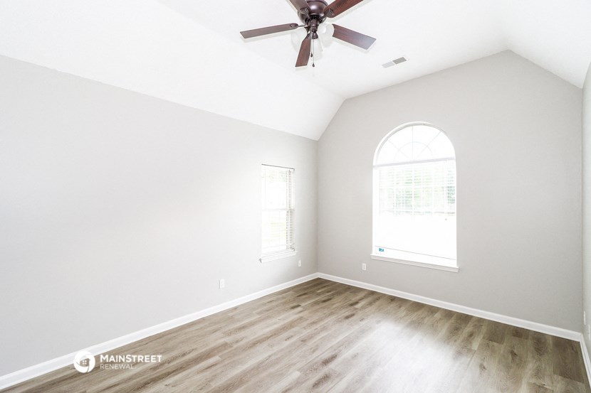 an empty room with white walls and a ceiling fan