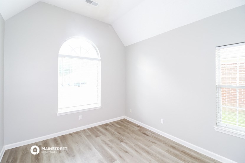 an empty room with white walls and wood floors
