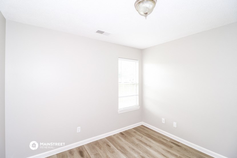 an empty room with white walls and a window