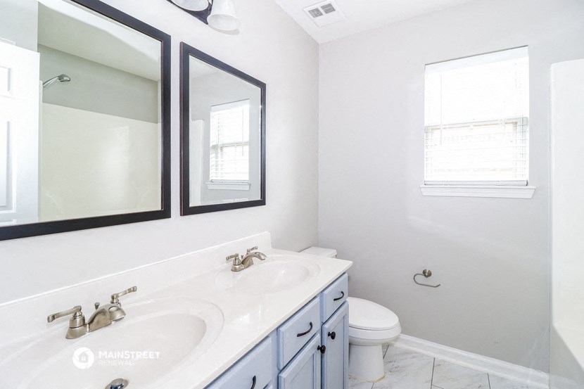 a bathroom with two mirrors and a sink and a toilet