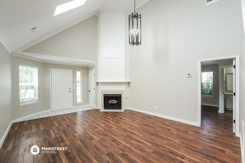 the living room with wood flooring and a fireplace
