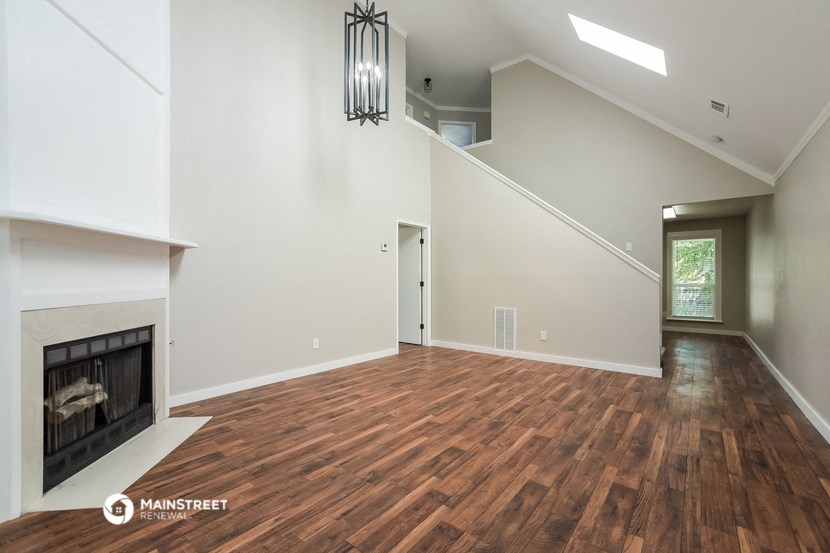 the living room has a fireplace and hardwood floors