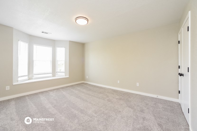 the spacious living room with carpeted flooring and large windows