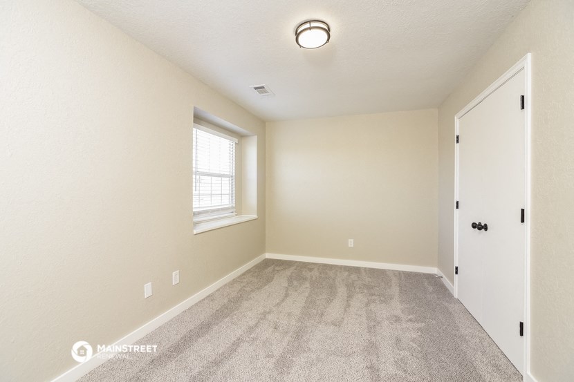 the spacious living room with carpet and a window
