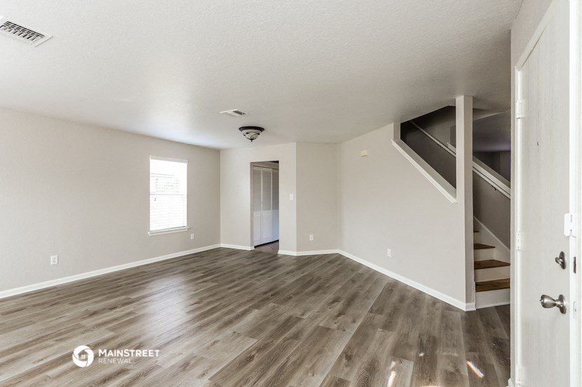 the living room and dining room with wood flooring and stairs