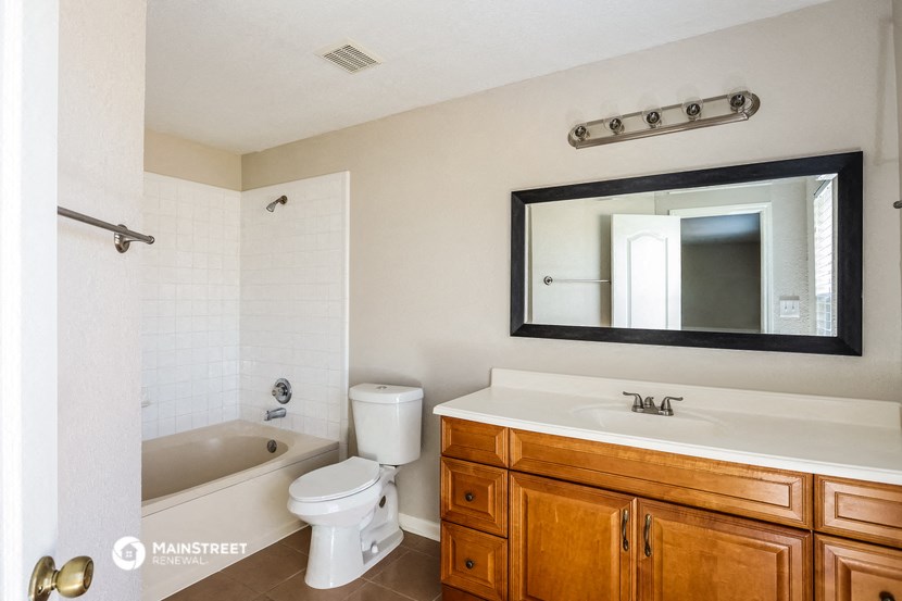 a bathroom with a sink toilet and tub and a mirror