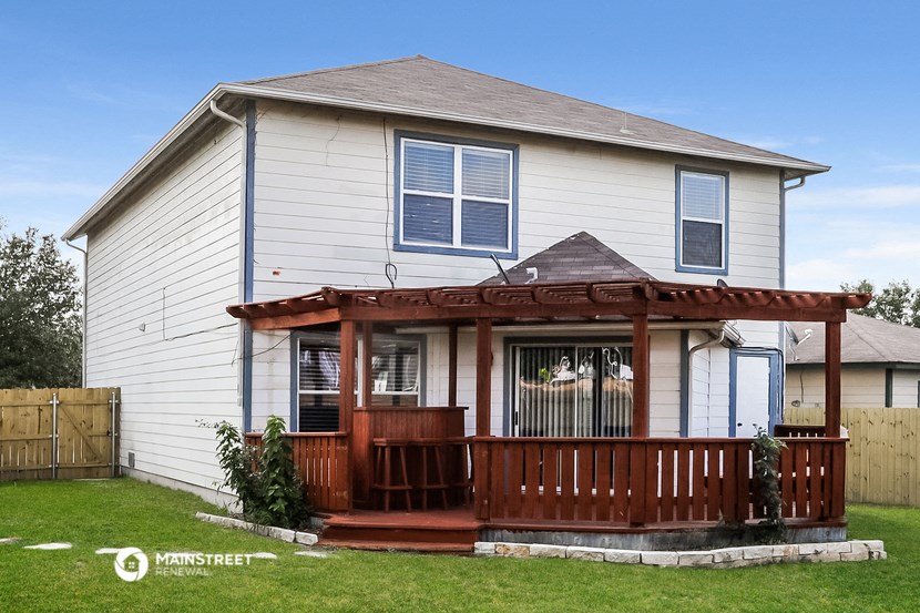 a white house with a porch and a wooden fence