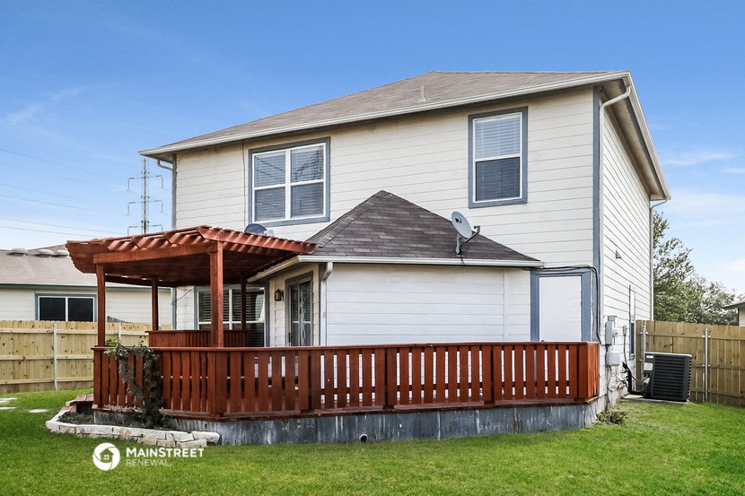 a white house with a porch and a wooden fence