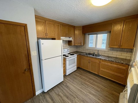 a kitchen with white appliances and wooden cabinets