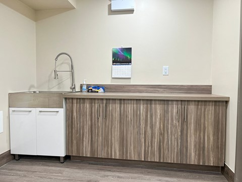 A kitchen with a wooden counter and white cabinets.