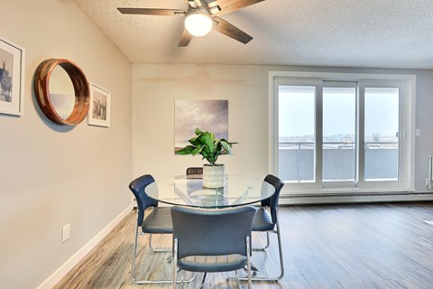 A dining room with a table and chairs.