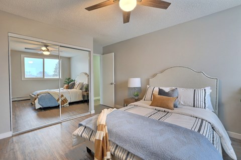 A bedroom with a large bed and a mirror on the wall.