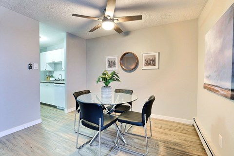 A dining room with a table and chairs.