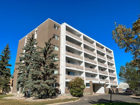A large, multi-story parking garage with a clear blue sky above.