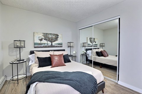 A bedroom with a large bed and a painting on the wall.