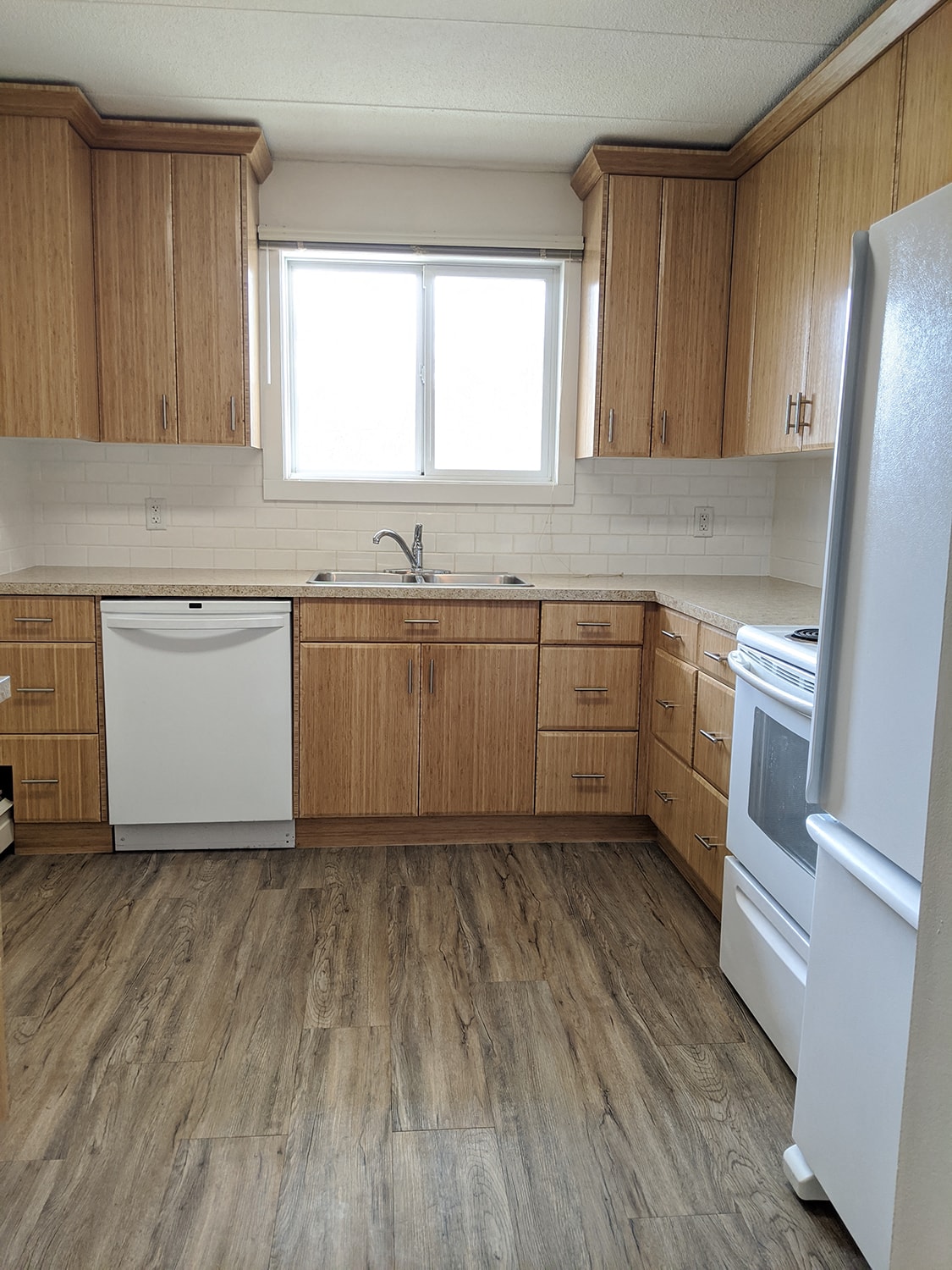 A kitchen with wooden cabinets and a white fridge.