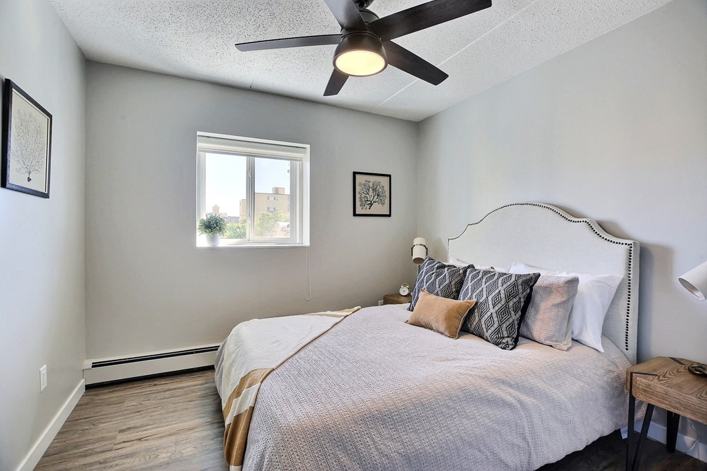 a bedroom with a large bed and a ceiling fan