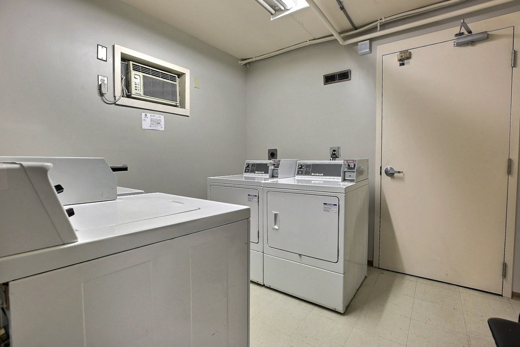 a laundry room with two washing machines and a door