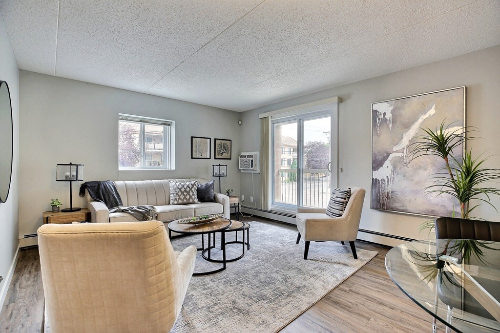 a living room with couches and chairs and a large window