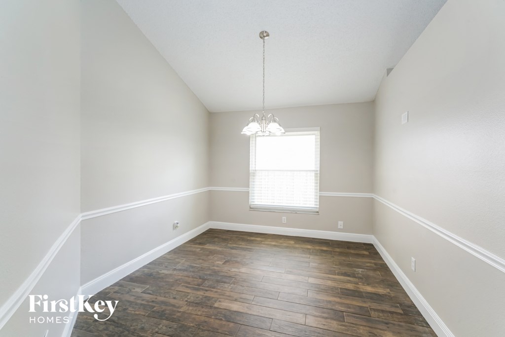 an empty living room with wood floors and white walls