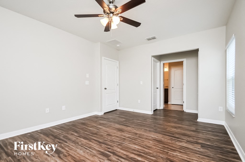 a living room with white walls and a ceiling fan