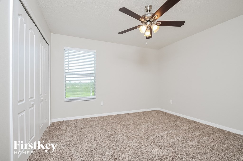 the living room of an empty home with a ceiling fan