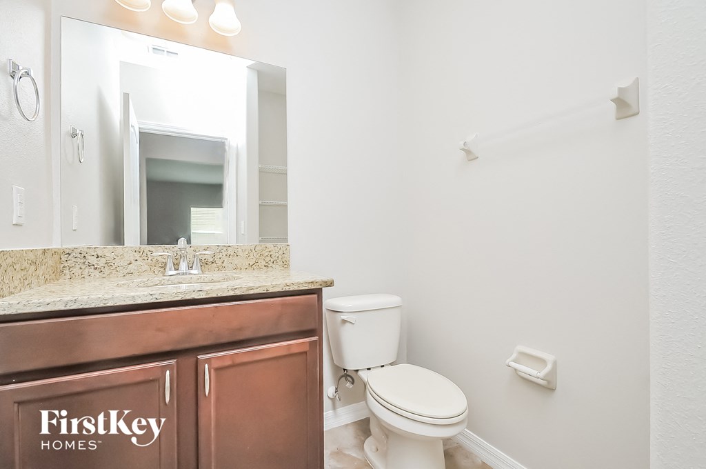 a bathroom with a toilet and a sink and a mirror