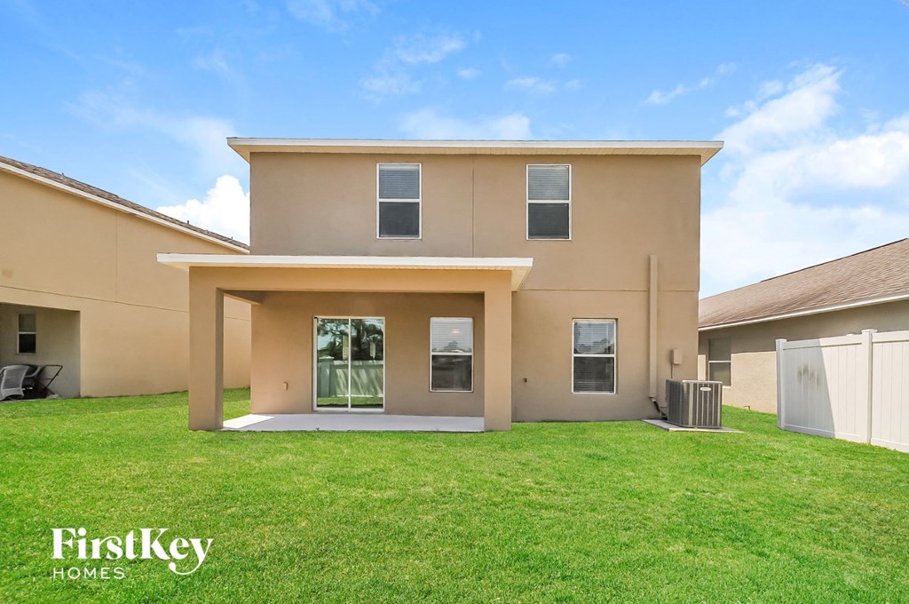 a beige house with a lawn in front of it