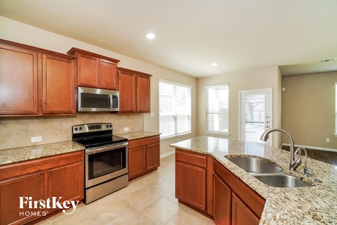 A kitchen with wooden cabinets and granite countertops.