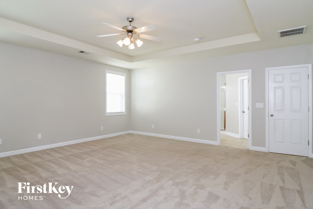 the master bedroom is spacious and has a ceiling fan