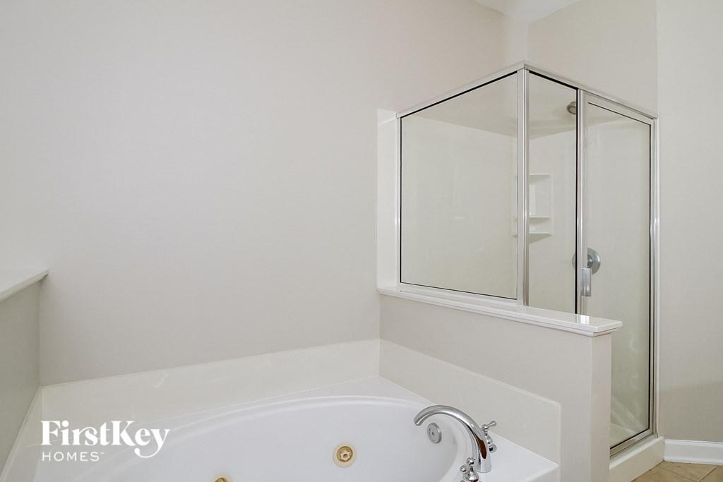 a bathroom with a tub and a shower and a sink